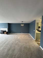 Unfurnished living room with carpet and a textured ceiling