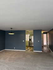 Unfurnished living room featuring dark carpet and sink