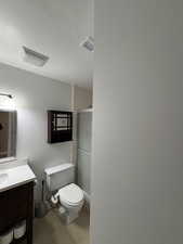 Bathroom with vanity, toilet, a shower with shower door, and tile patterned floors