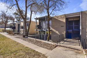 Exterior space with brick siding, fence, and a balcony