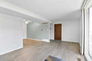 Spare room featuring baseboards, visible vents, and light wood-style floors