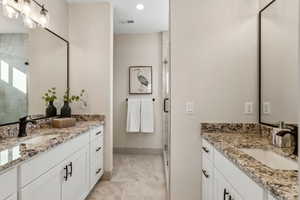 Bathroom featuring vanity and a shower with door