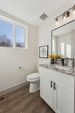 Bathroom featuring hardwood / wood-style flooring, vanity, and toilet