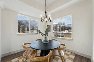 Dining area featuring dark wood-type flooring, a mountain view, and a notable chandelier