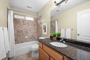 Full bathroom featuring tile patterned flooring, shower / bathtub combination with curtain, vanity, and toilet