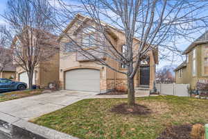 View of property featuring a front lawn and a garage