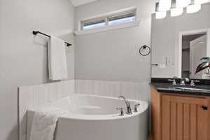 Bathroom featuring vanity and a corner bathtub