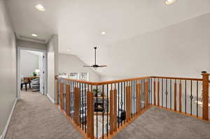 Corridor with light carpet and lofted ceiling