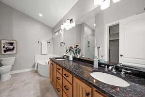 Full owner's suite bathroom featuring tile patterned flooring, toilet, lofted ceiling, independent shower and bath, and vanity- new about 2 years ago.