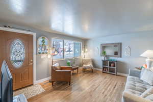 Entryway with light wood-type flooring, visible vents, and baseboards