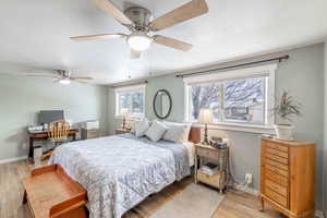 Bedroom with a textured ceiling, light wood-type flooring, and baseboards