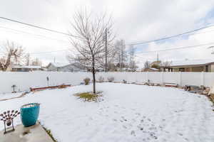 Yard covered in snow with a fenced backyard