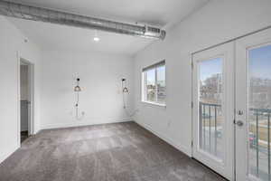 Carpeted spare room featuring french doors