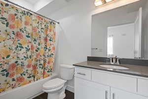 Full bathroom featuring toilet, vanity, and shower / bath combination with curtain