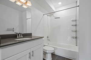 Full bathroom featuring toilet, vanity, and tiled shower / bath