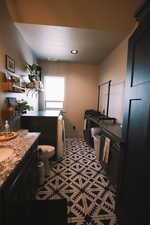 Secondary bathroom with aztec tiling, a washer and dryer and counter top space.