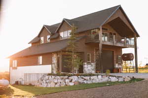 View of property exterior featuring stone siding, large garage and a balcony.