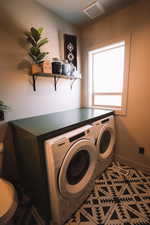 Clothes washing area featuring laundry area, independent washer and dryer, and baseboards