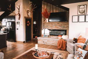 Living room with a fireplace, wood finished floors, and granite counter tops.