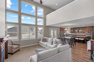 Living room featuring french doors, hardwood / wood-style flooring, and ceiling fan with notable chandelier