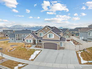 View of front of property with a mountain view, a front yard, and a garage
