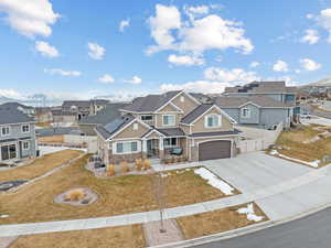 View of front of home with a mountain view, a garage, and a front lawn