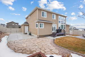 Rear view of property featuring a lawn, a wooden deck, and a patio area