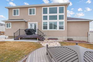 Back of house with a yard and a wooden deck
