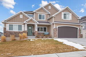 Craftsman inspired home with a garage and a front yard