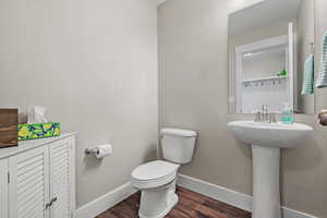 Bathroom with hardwood / wood-style flooring and toilet