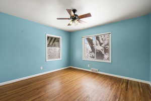 Unfurnished room with hardwood / wood-style floors and ceiling fan