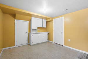 Kitchen with white cabinets and a textured ceiling