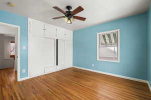 Unfurnished bedroom with hardwood / wood-style flooring, ceiling fan, and a closet