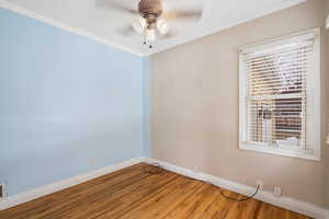 Spare room featuring ceiling fan, crown molding, and hardwood / wood-style floors