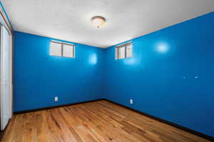 Spare room with hardwood / wood-style flooring, a textured ceiling, and a healthy amount of sunlight