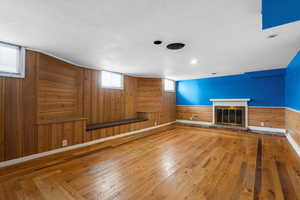 Unfurnished living room with wood walls and wood-type flooring