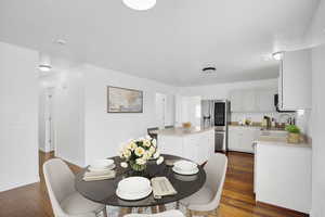 Dining area with baseboards and dark wood-type flooring