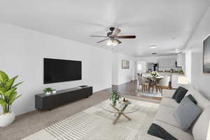 Living area featuring a ceiling fan, carpet flooring, and baseboards