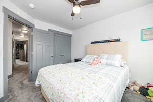 Bedroom with visible vents, a closet, light carpet, a textured ceiling, and a ceiling fan