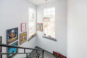 Stairs featuring a notable chandelier, baseboards, and carpet