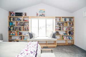 Bedroom with baseboards, vaulted ceiling, and carpet