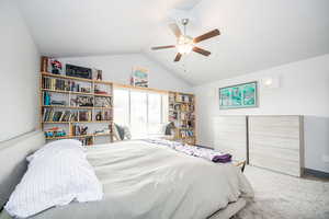 Carpeted bedroom featuring a ceiling fan and lofted ceiling