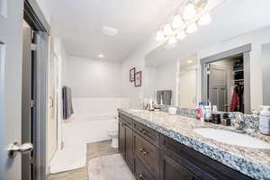 Bathroom with a sink, a stall shower, double vanity, and a spacious closet