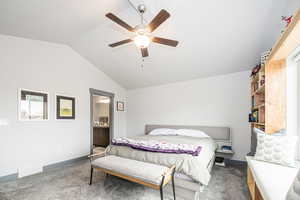 Bedroom with baseboards, visible vents, lofted ceiling, connected bathroom, and carpet