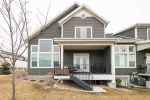 Back of property featuring stucco siding, a yard, and cooling unit