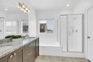 Bathroom with a stall shower, a garden tub, and a sink