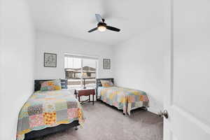 Carpeted bedroom with a ceiling fan and baseboards