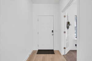 Entryway with baseboards and light wood-style floors