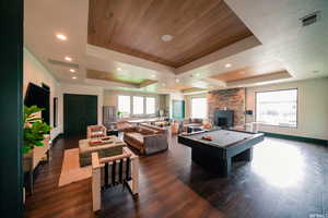 Recreation room with dark wood-type flooring, a raised ceiling, and visible vents