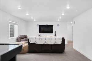 Living area featuring light carpet, recessed lighting, and baseboards